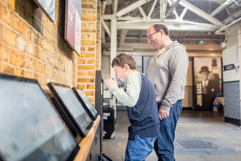 A boy and his father look at information panels at Tower Bridge