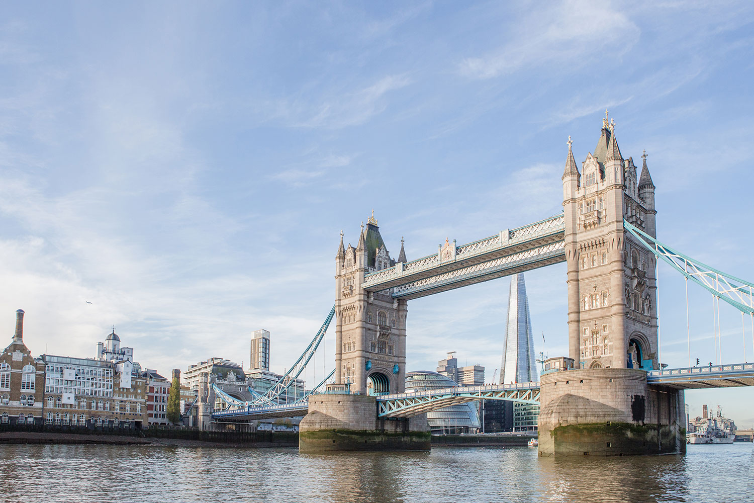 A view of Tower Bridge from the North side of the River Thames on a bright sunny day