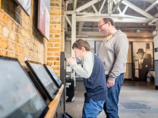 A boy and his father look at information panels at Tower Bridge