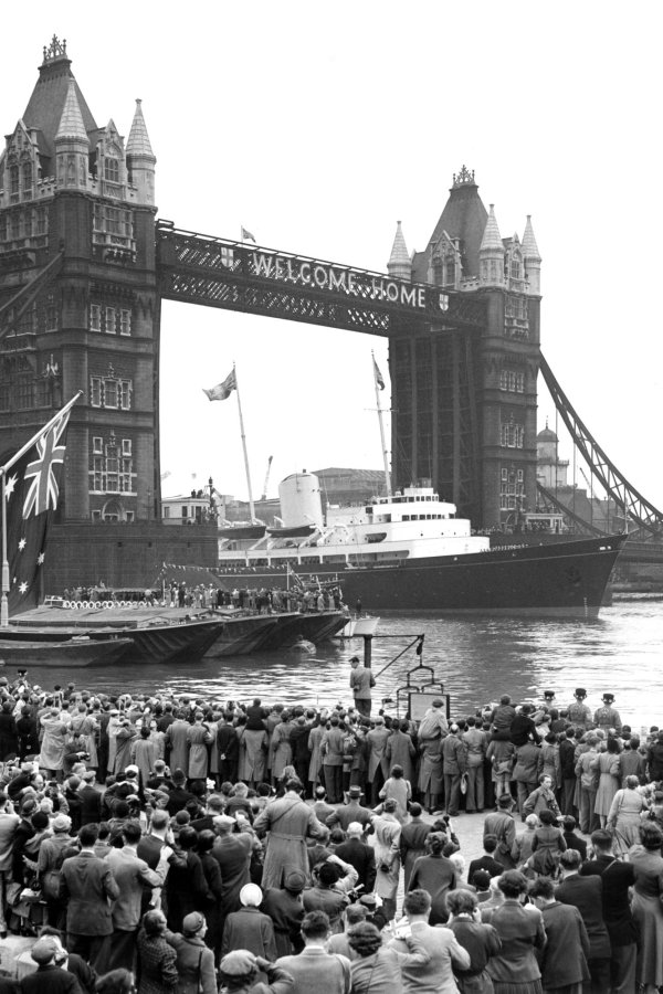 Black and white photo of the Royal Yacht Brittania sailing through Tower Bridge