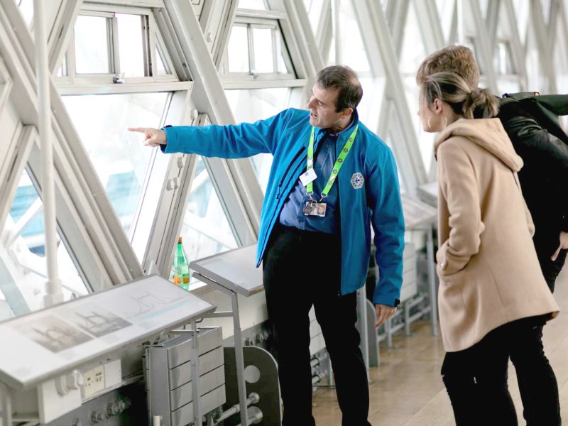 A guide shows visitors the views out of the Walkways