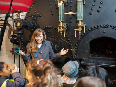 A teacher and pupils look at Tower Bridge's coal boilers