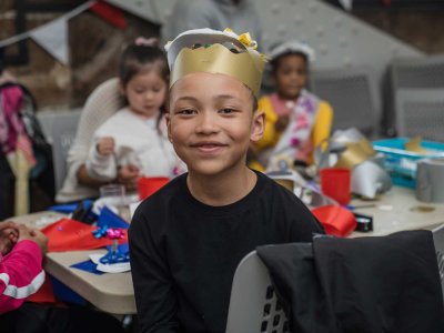 Boy wearing a crown takes part in family activities at Tower Bridge