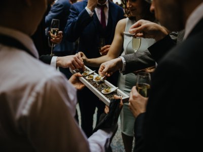 People reaching for canapes at an event