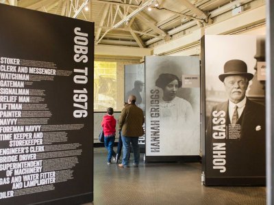 Three visitors explore the exhibition in the Engine Rooms