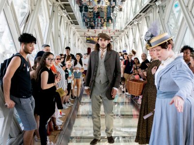 People in Victorian costume stand on the Glass Floors in Tower Bridge's Walkways