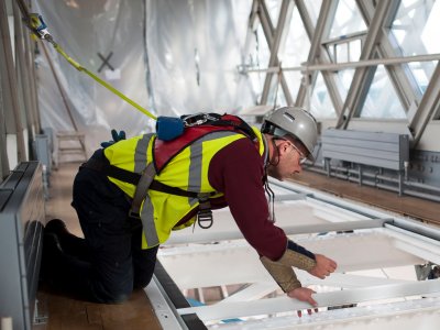 A man installing the Glass Floor inside the Tower Bridge Walkways
