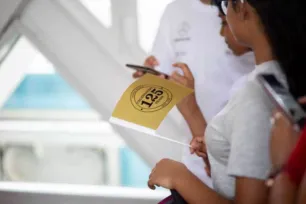 A visitor holds a gold '125' flag, walking along the High-level Walkway