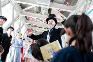 A man in Victorian attire giving a speech to visitors at Tower Bridge