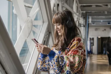A woman listening to the Audio Tour in Tower Bridge on the Walkways