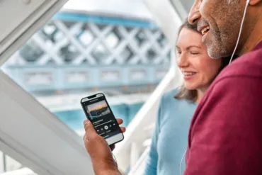 A couple holding their phone listening to the Tower Bridge audio tour
