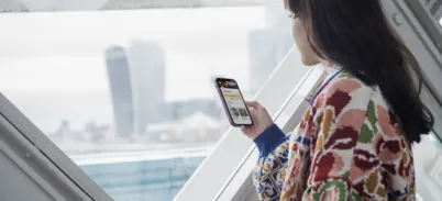 Woman looking at her phone listening to an audio tour on Tower Bridge Walkways