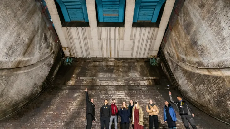A group of visitors and an expert guide in the Bascule Chambers of Tower Bridge