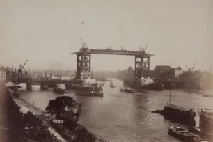 A sephia photo of Tower Bridge's steel structure being constructed.