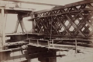 A sephia close-up photo of Tower Bridge's steel grid-like structure during construction.