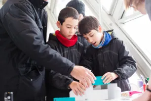 Two children and an adult participating at an activity at Tower Bridge