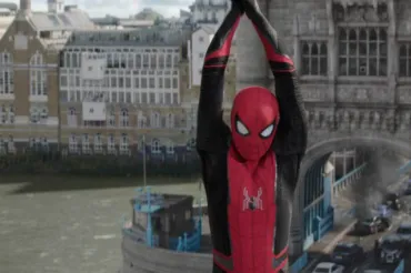Spiderman dressed in his suit is hanging from Tower Bridge