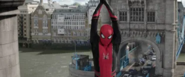 Spiderman dressed in his suit is hanging from Tower Bridge