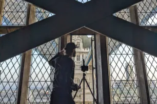 A videographer filming out the window