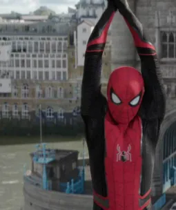 Spiderman dressed in his suit is hanging from Tower Bridge