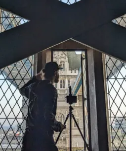 A videographer filming out the window