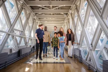 A group of visitors and an expert guide in the High-level Walkways of Tower Bridge