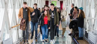 A small group of people walk on the Glass Floor