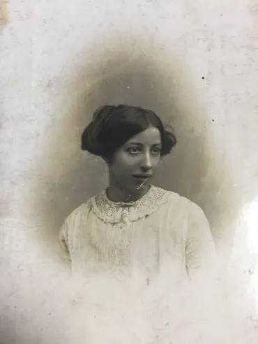 An old sepia photo of Hannah wearing a white lace dress and looking away from the camera.
