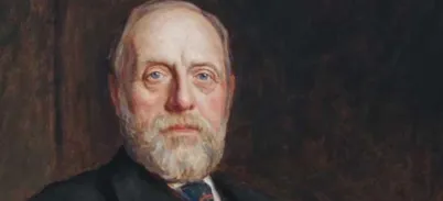 A portrait of a man in a black suit, with white hair and moustache