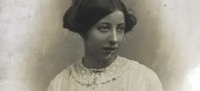 An old sepia photo of Hannah wearing a white lace dress and looking away from the camera.
