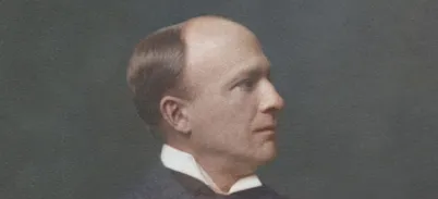 Vintage portrait of Engineer George Edward Wilson Cruttwell wearing a dark suit jacket, white collared shirt, and a dark tie, set against a plain dark background. The image has a classic, formal style typical of early 20th-century Victorian photography.