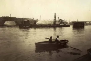 A sephia photo showing a rowing boat in the foreground on the river Thames