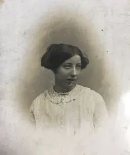 An old sepia photo of Hannah wearing a white lace dress and looking away from the camera.