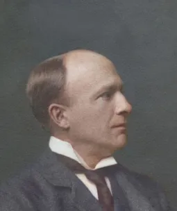 Vintage portrait of Engineer George Edward Wilson Cruttwell wearing a dark suit jacket, white collared shirt, and a dark tie, set against a plain dark background. The image has a classic, formal style typical of early 20th-century Victorian photography.