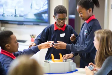 Three school children working together in a workshop.