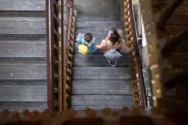 Two people walking down the stairwell at Tower Bridge.