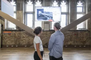 Two visitors watching an informative video at the South Tower of Tower Bridge.