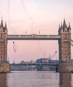 Two men in wingsuit flying through Tower Bridge