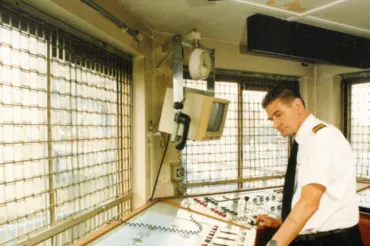 Bill Skinner in the modern Tower Bridge control room standing over a panel of controls and buttons.