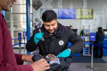 A security welcome host carrying out a bag search at the entrance of Tower Bridge.