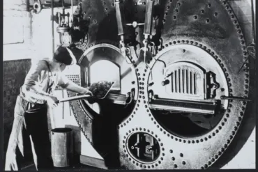 Unknown stoker putting goal in the boiler of the Engine at Tower Bridge.