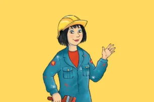 A young woman in overalls and a yellow hard hat, holding a paint brush.