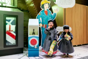Two children at Tower Bridge with a brochure in hand, participating in the Tower Bridge Cat Trail