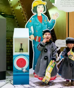 Two children at Tower Bridge with a brochure in hand, participating in the Tower Bridge Cat Trail