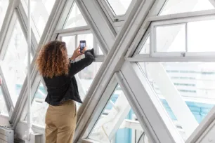 A visitor taking pictures of the views through the camera windows on the Walkways at Tower Bridge.