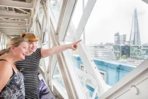 Two ladies looking out of the windows on the High-level Walkways.