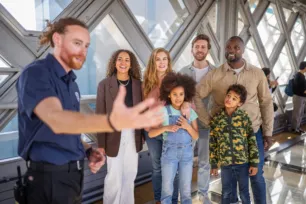 An expert guide and a group of visitors on the Walkways of Tower Bridge