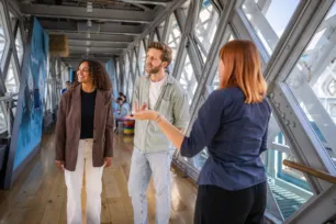 An expert guide and two visitors on the Walkways at Tower Bridge.