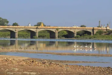 A long stone bridge crosses a body of water