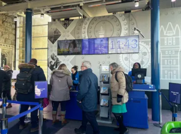 People buying tickets from uniformed staff